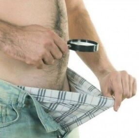 un uomo si guarda sotto i pantaloni e vuole ingrandire il suo pene con il gel